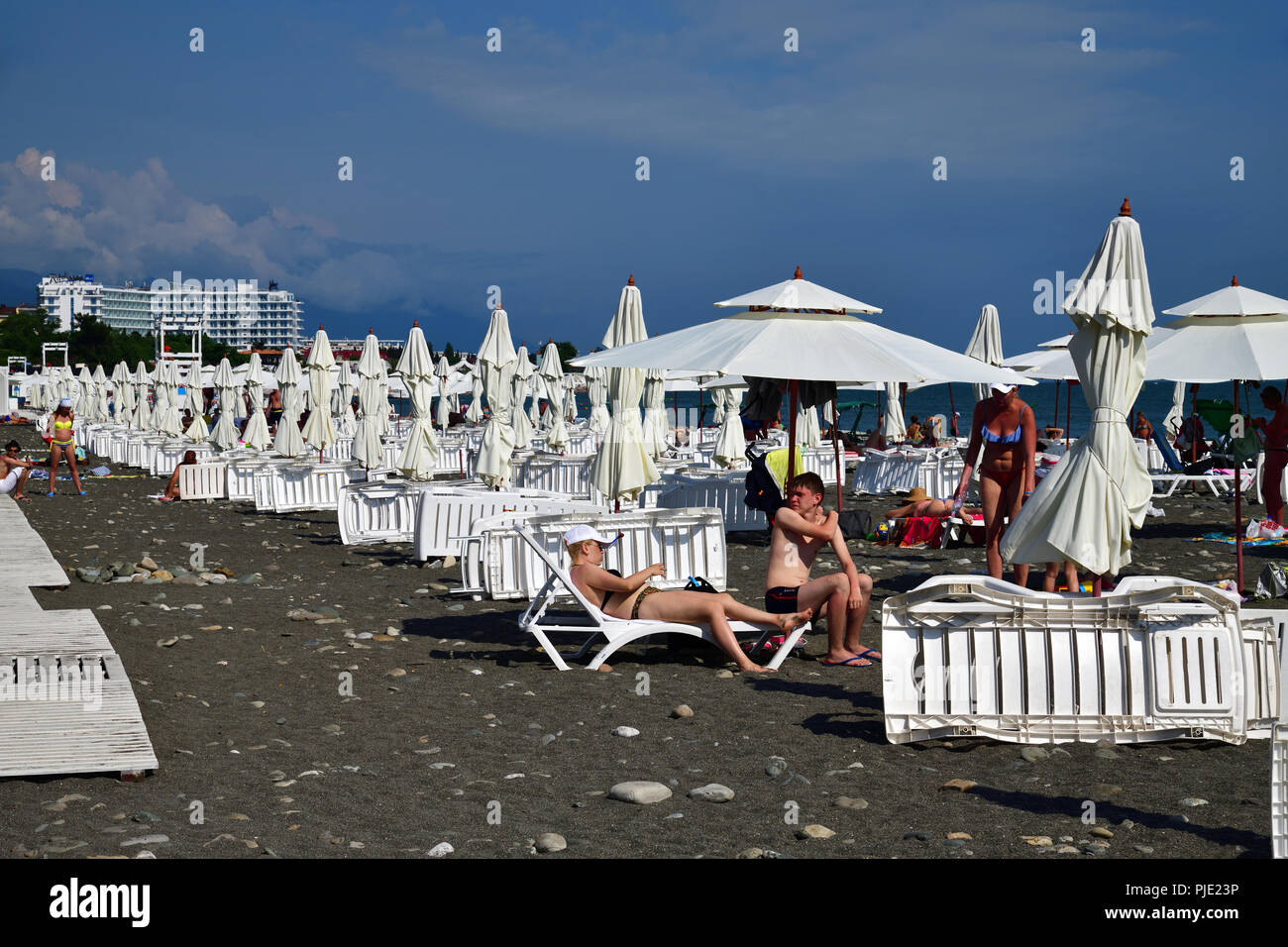 Sochi, Russland - Juni 5. 2018 Leute am Strand mit Sonnenschirmen und Liegestühlen. Stockfoto