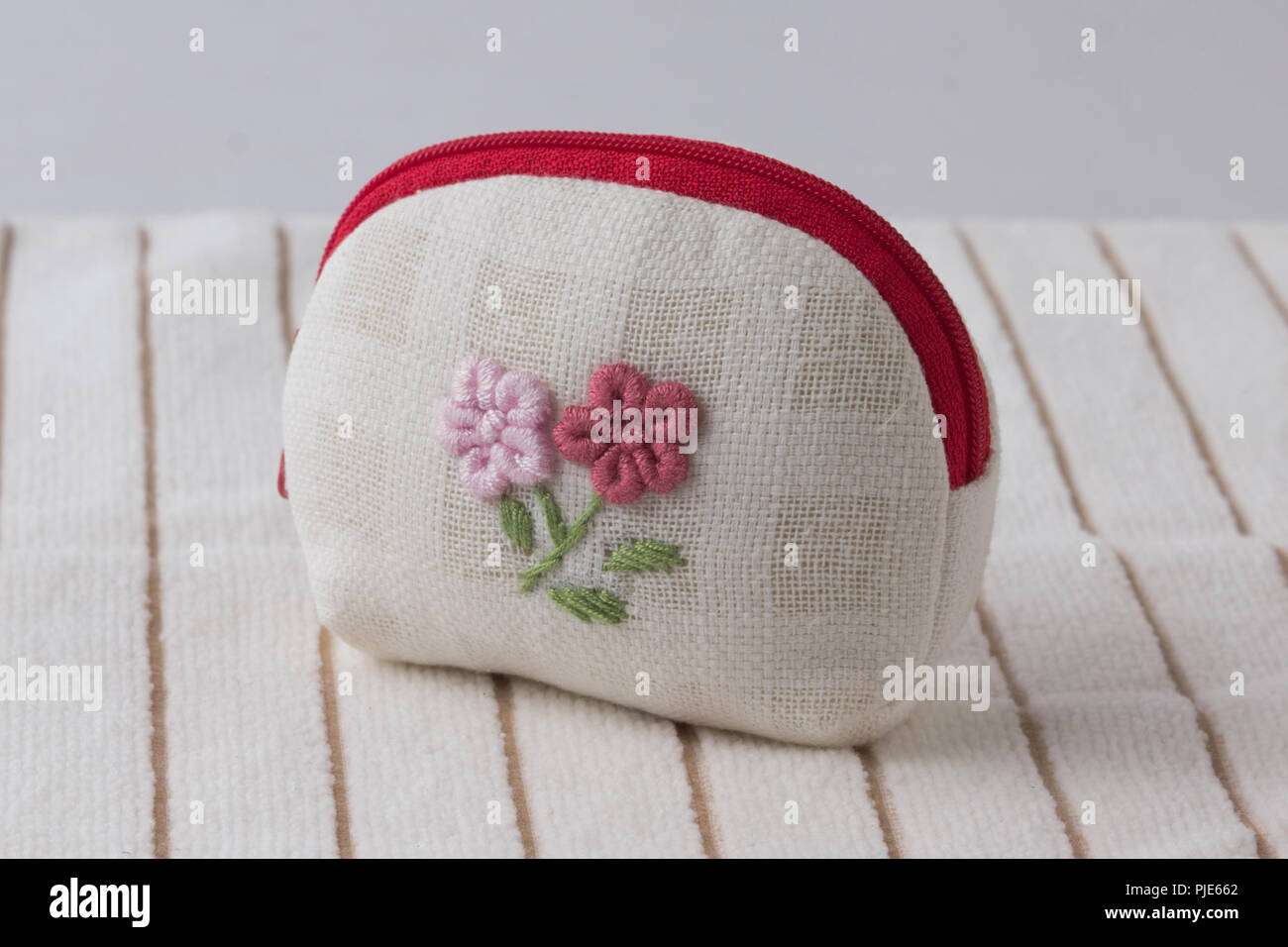 Gewebe Geldbeutel mit reizenden Blumen Stickerei auf weißem Hintergrund Tuch Stockfoto