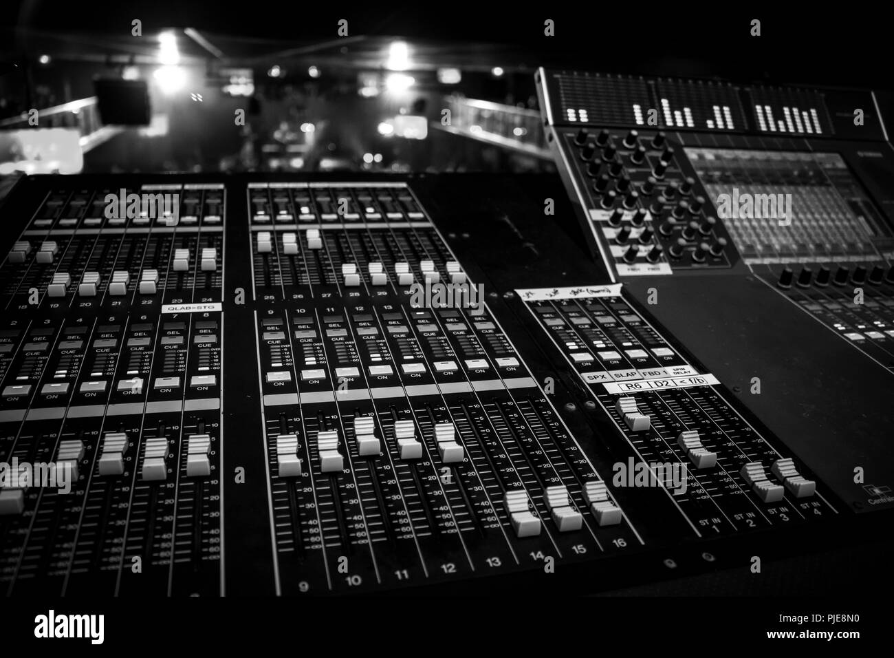 In der breiten Ansicht von professionellen Audio Sound Mixing Console mit Künstler, die auf dem entfernten Hintergrund, Monochrom schwarz-weiß Stil Stockfoto