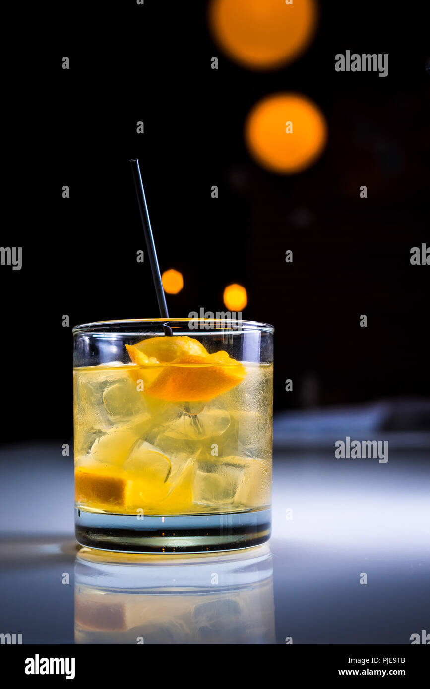 Ein Handwerk Cocktail mit orangen Garnitur in ein Glas mit Eiswürfeln auf schwarzem Hintergrund Stockfoto