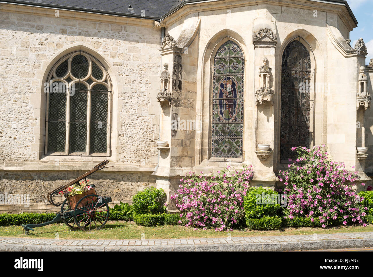 Alte Sprinklerpumpe und Blumenarrangement außerhalb der Kirche des Hl. Vinzenz, Hermes, Département de l'Oise, Frankreich, Europa Stockfoto