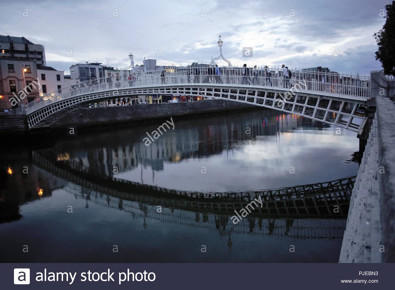 Abends Licht in den Himmel über dem ikonischen Ha'Penny Bridge, die den Fluss Liffey in Dublin, Irland kreuzt. Stockfoto
