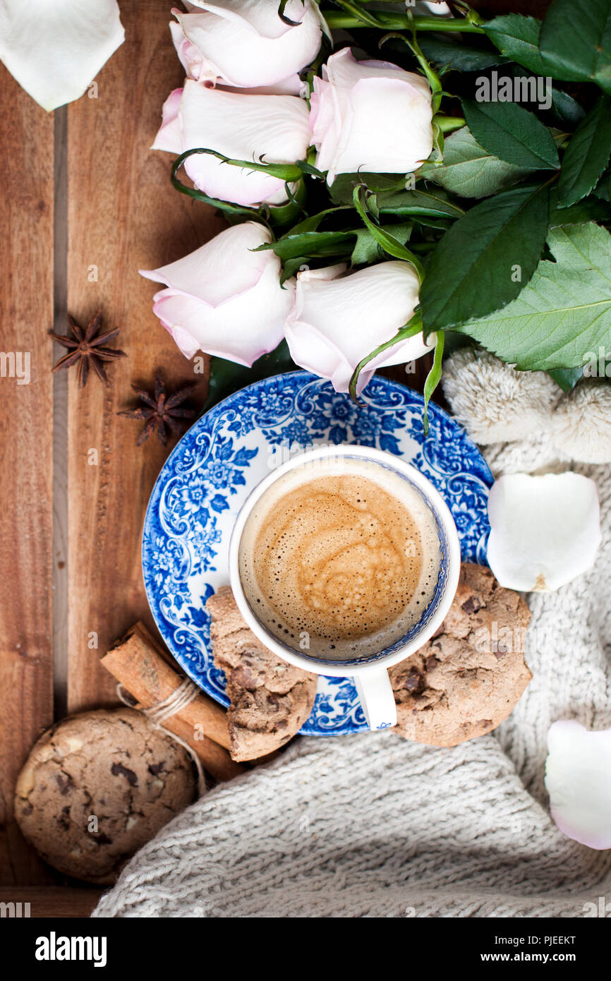 Romantische Kaffee in einer Tasse auf einem hölzernen Hintergrund mit einem Plaid, ein Blumenstrauß aus den weißen Rosen und im Herbst Gemütlichkeit. Guten Morgen. obere Ansicht. Kopieren Sie spase, Stockfoto