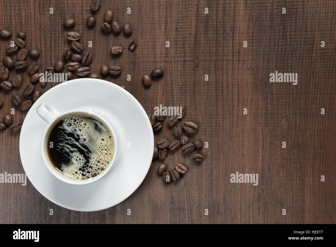 Tasse Kaffee auf der Holz- Hintergrund mit Kaffeebohnen, Ansicht von oben Stockfoto