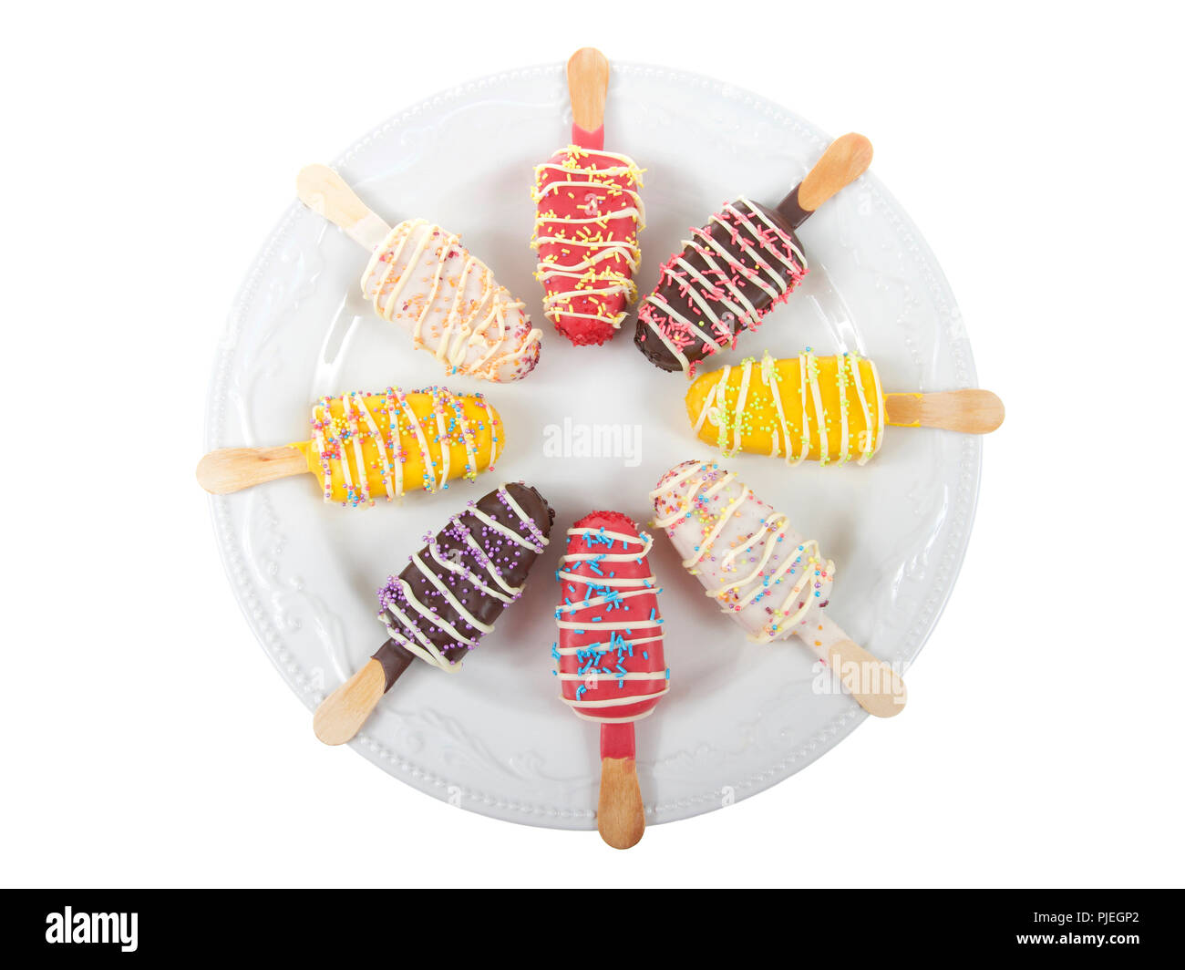 Mehrere farbige Candy abgestreift popsicle Kuchen mit Streuseln oben auf ein aus weißem Porzellan Platte auf weißem Hintergrund erscheint. Spaß Party Food Stockfoto