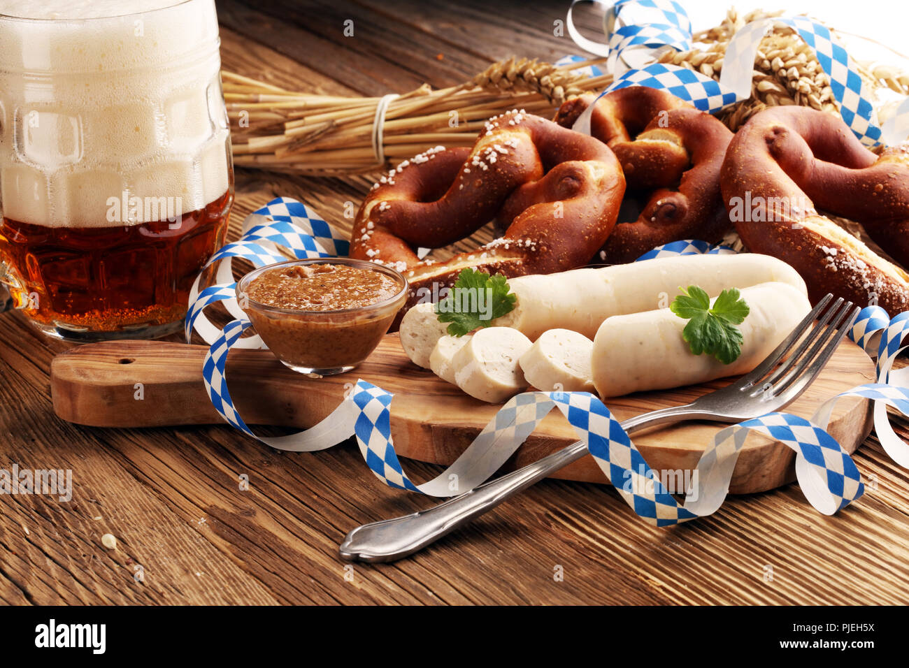 Weißwurst Frühstück mit Würstchen, weiche Brezel und Milder Senf auf Holzbrett aus Deutschland. Stockfoto