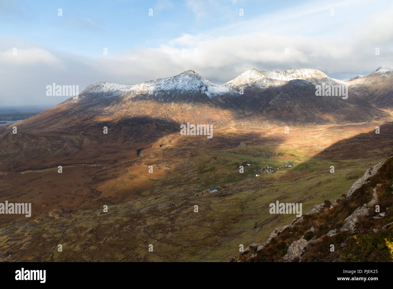 Sonnenlicht und Schatten auf die Twelve Bens Berge im Winter, Connemara, County Galway, Irland. Stockfoto