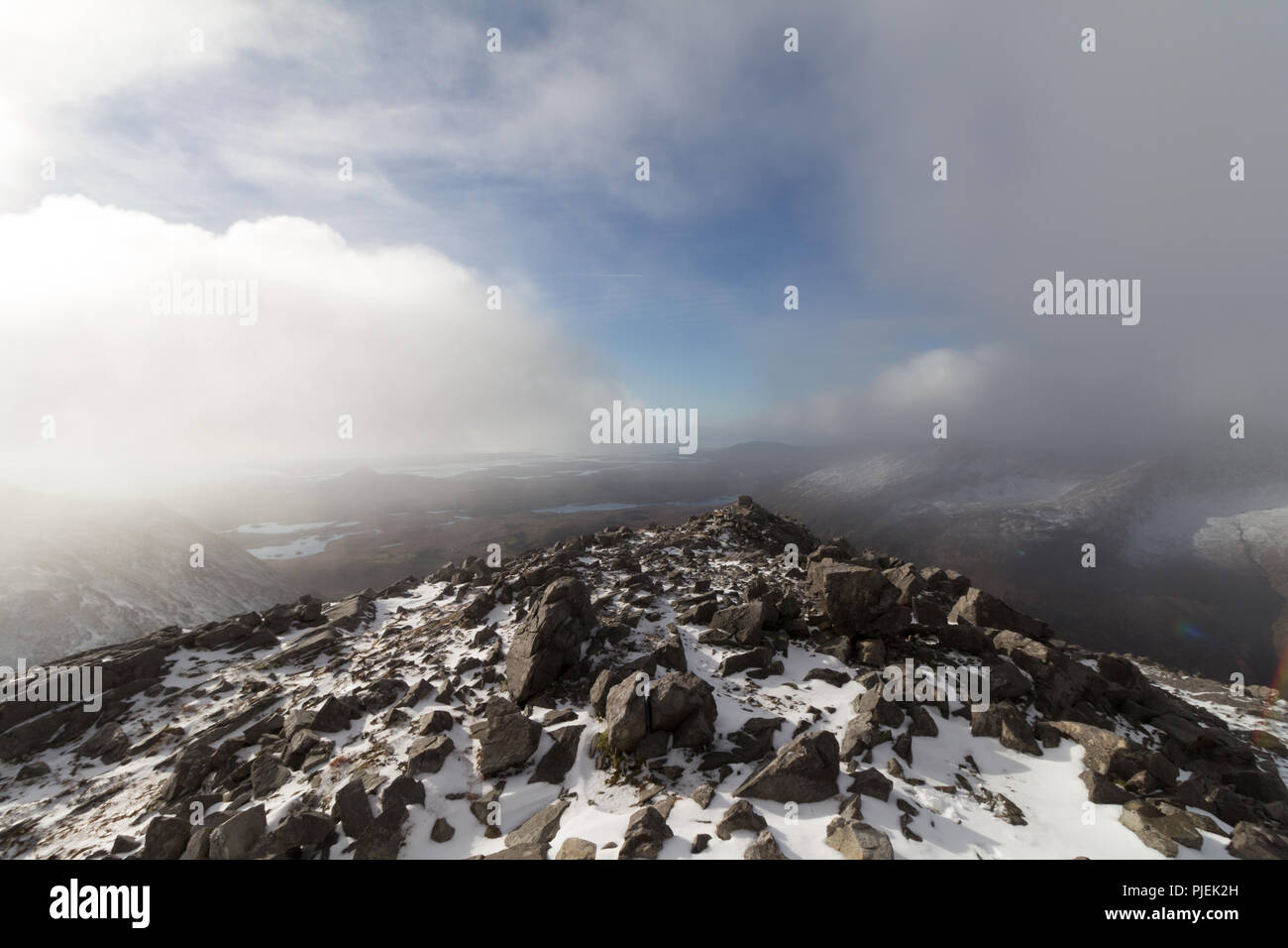 Zu Fuß durch die Wolken auf einem Bergrücken auf die Twelve Bens Berge in Connemara, Irland. Stockfoto