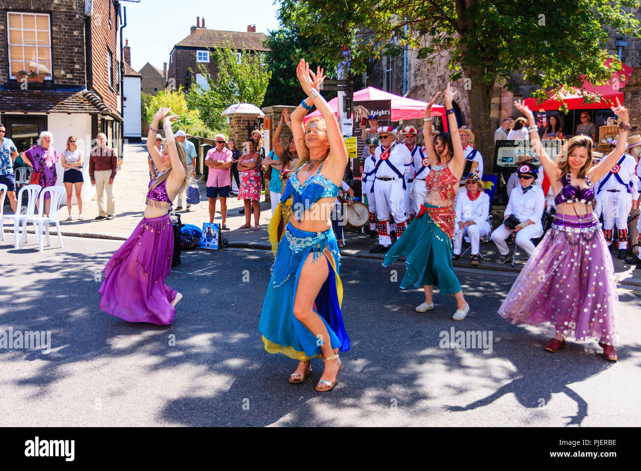 Reife Frauen von Bauchtanz Gruppe der "guten Karma Damen in einer Straße in der Stadt Sandwich, Kent durchführen, als Teil der Folk- und Ale-Festival. Stockfoto