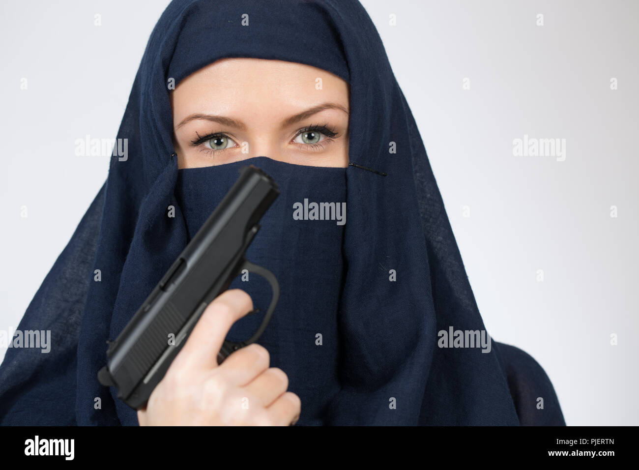 Die muslimische Frau im schwarzen Kleid vor einem dunklen Hintergrund Stockfoto