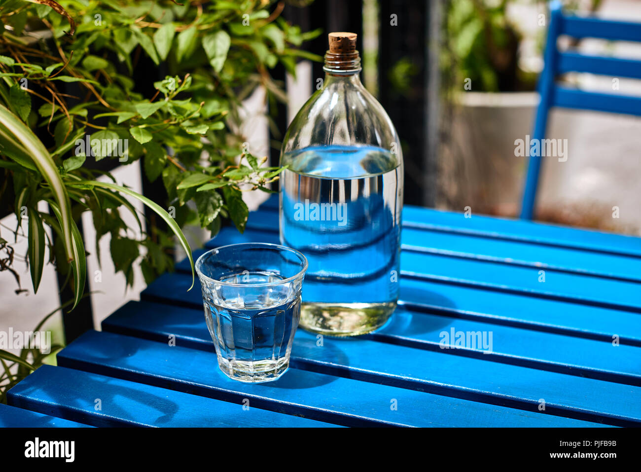 Glas mit Leitungswasser auf dem blauen Hintergrund Stockfoto