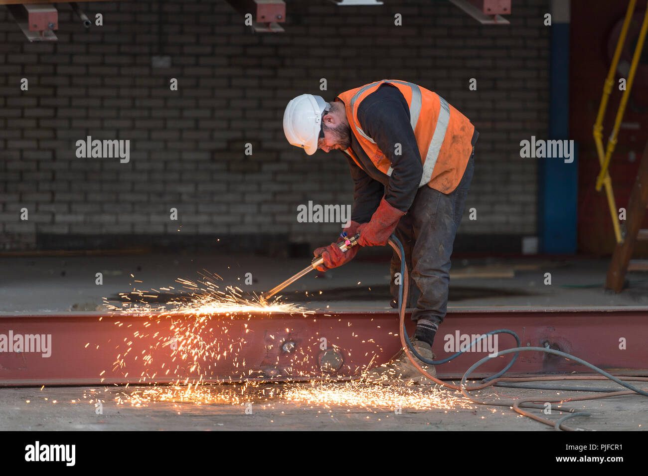 Baustelle Arbeiter schneiden einen Strahl mit einem Azetylen-fackel Stockfoto