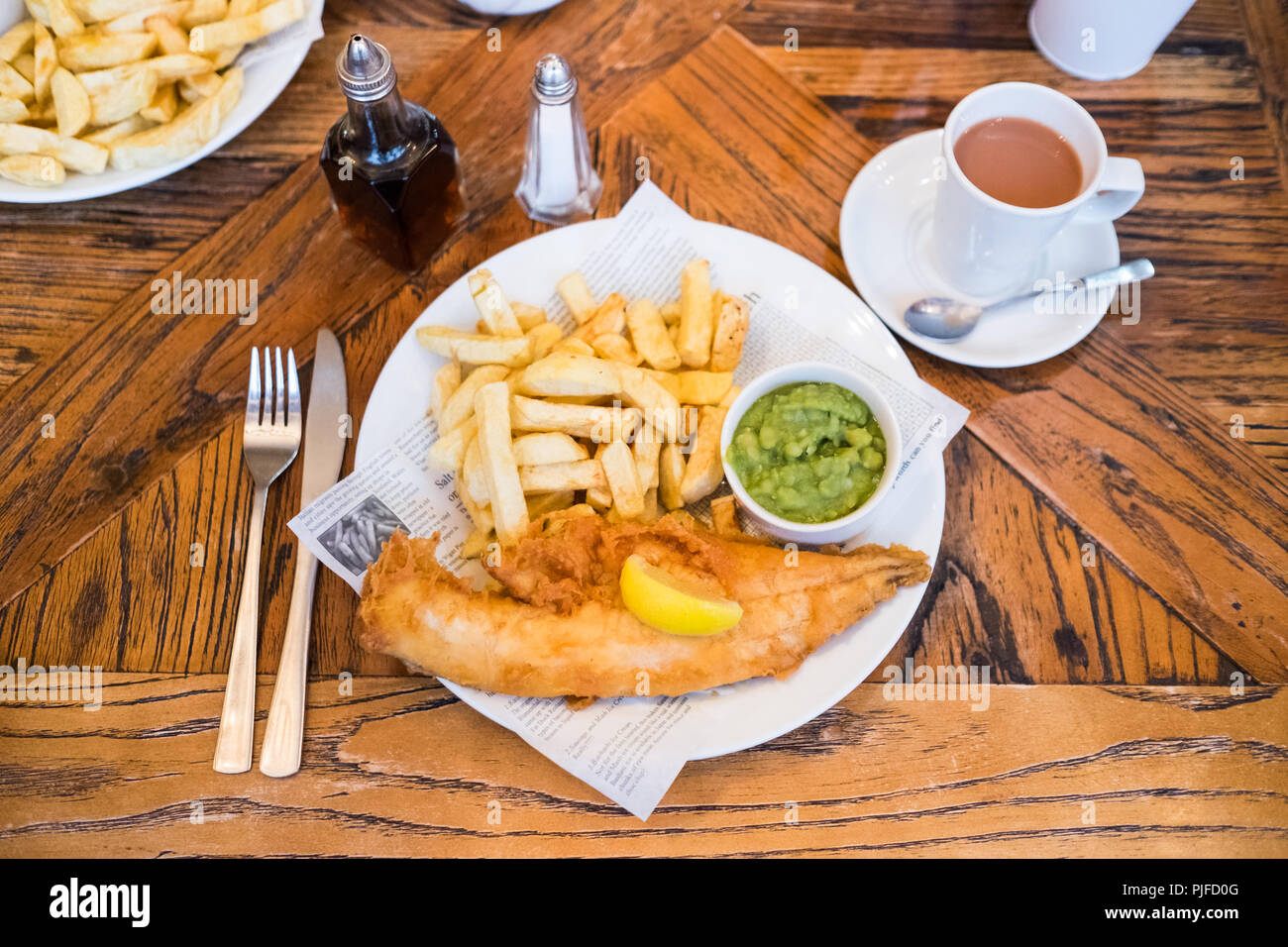 Schellfisch und Chips mit Erbsenpüree bei Lewis's Fish Restaurant, Nevsehir, Northumberland, England Stockfoto