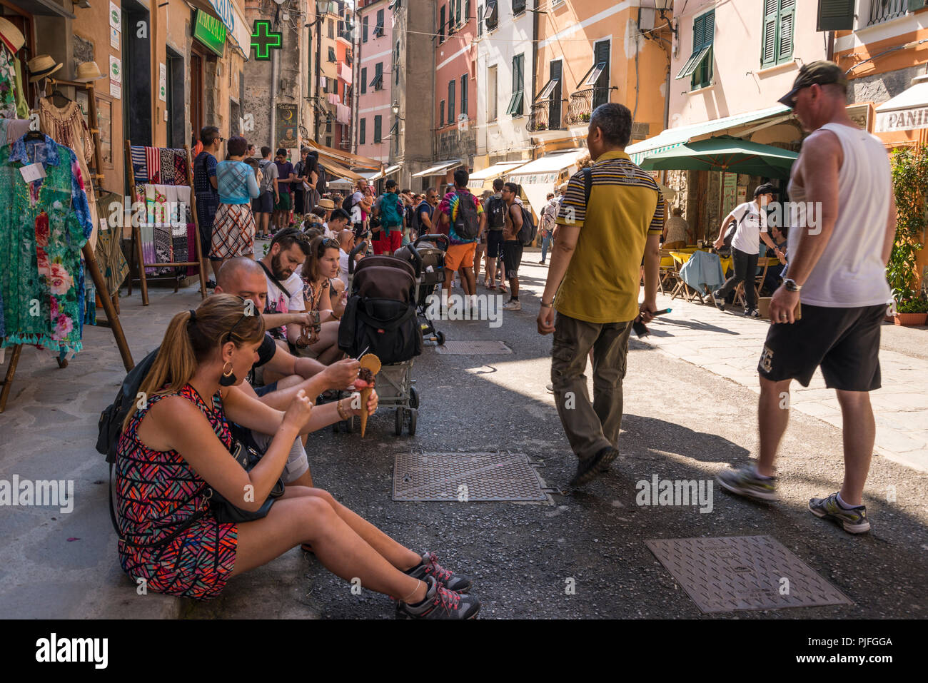 Touristen sitzen und in Ruhe beim Essen Eis im Schatten, Vernazza, einer der 5 Dörfer der Cinque Terre, Ligurien, Italien Stockfoto