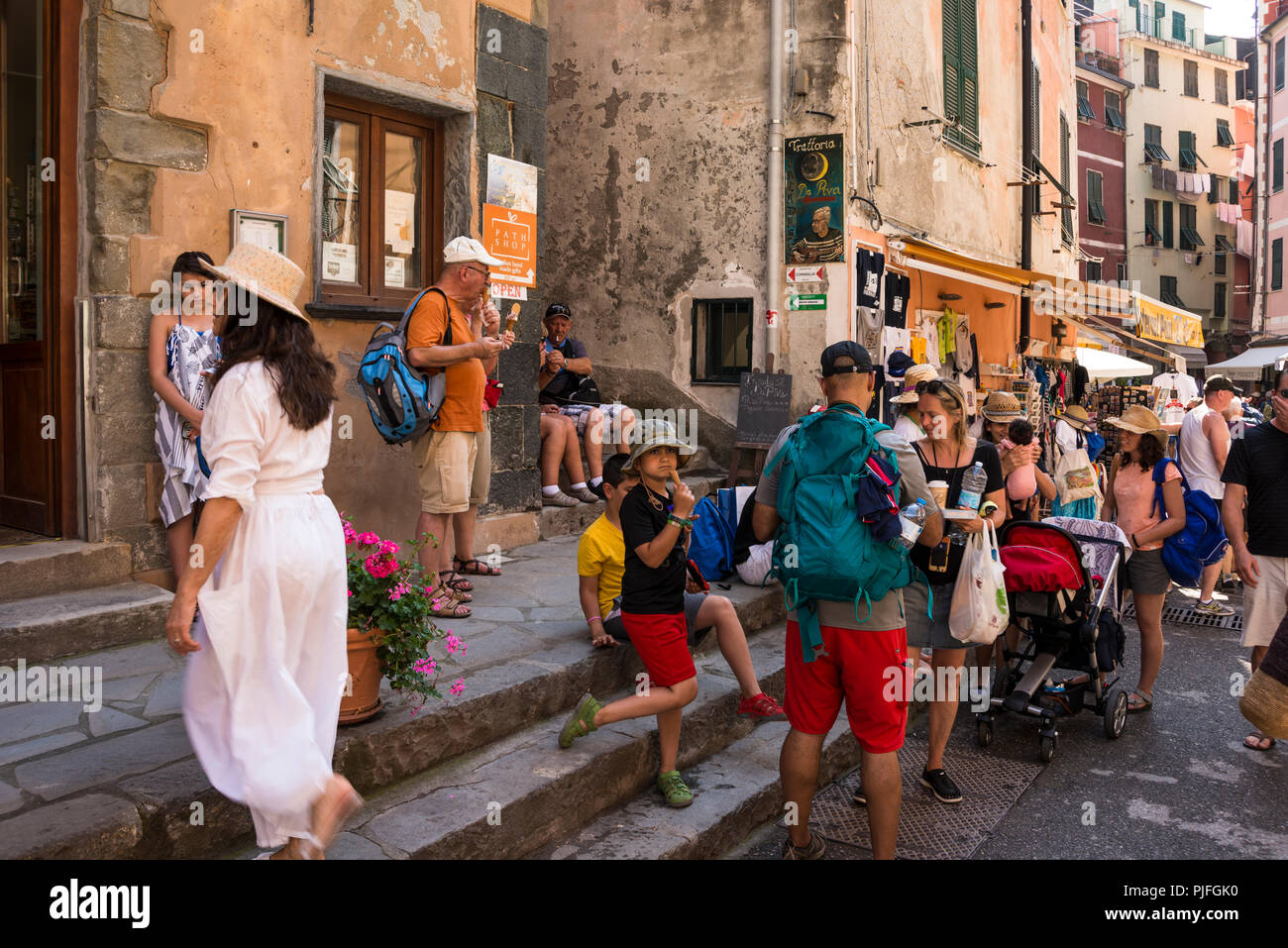 Touristen sitzen und in Ruhe beim Essen Eis im Schatten, Vernazza, einer der 5 Dörfer der Cinque Terre, Ligurien, Italien Stockfoto