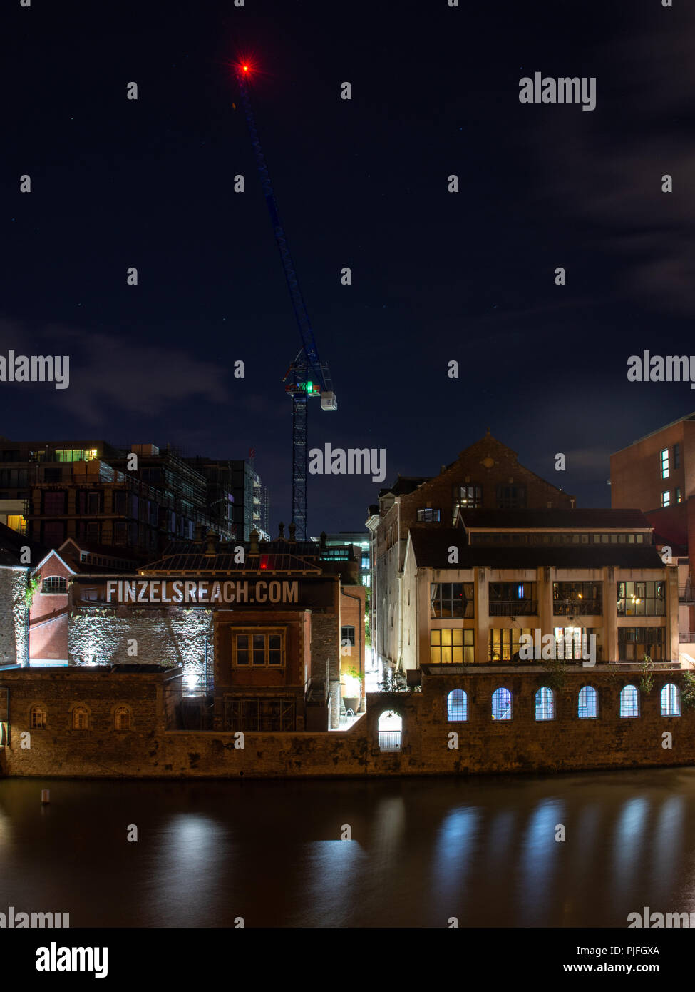 Bristol, England, Großbritannien - 9 August, 2018: ein Turm Kran ist in der Nacht auf Finzel von Reach auf Bristol's lit Schwimmenden Hafen, wo alte industrielle Gebäude i Stockfoto