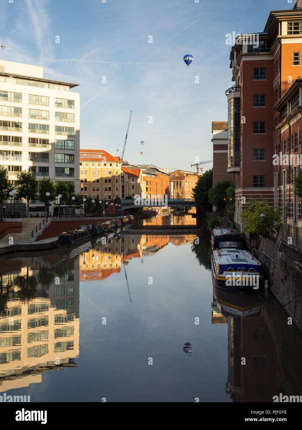 Bristol, England, Großbritannien - 11 August 2018: Heißluftballone fliegen über moderne Bürogebäude an der Temple Quay an Bristol Schwimmenden Hafen in der Dämmerung während Stockfoto
