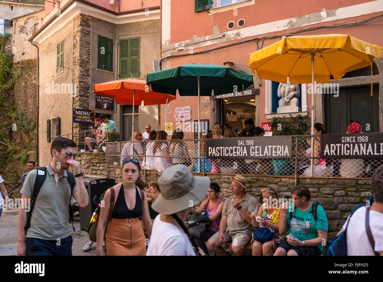 Touristen sitzen und in Ruhe beim Essen Eis im Schatten, Vernazza, einer der 5 Dörfer der Cinque Terre, Ligurien, Italien Stockfoto