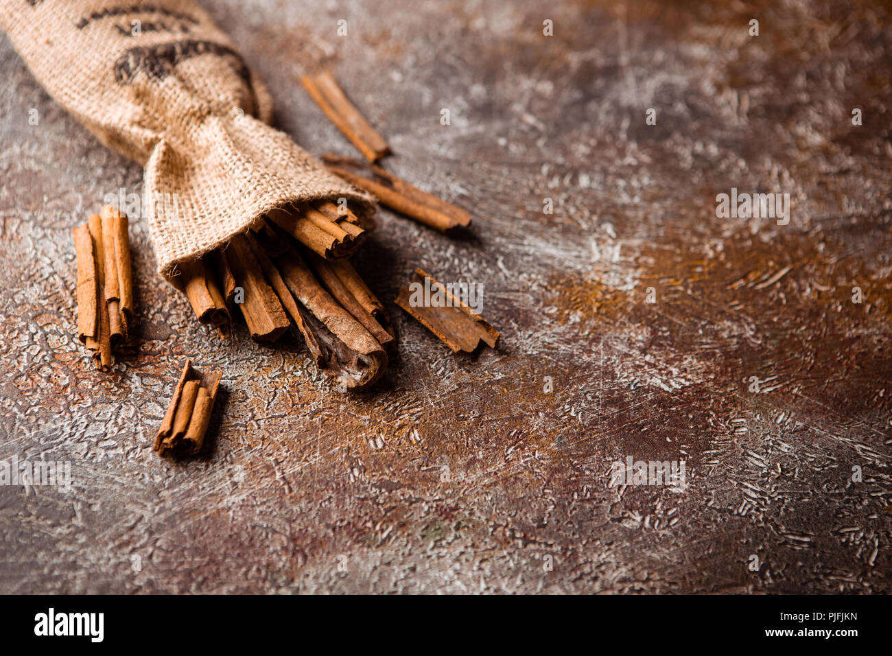 Zimtstangen in einem Canvas Tasche auf grunge braunen Hintergrund Stockfoto