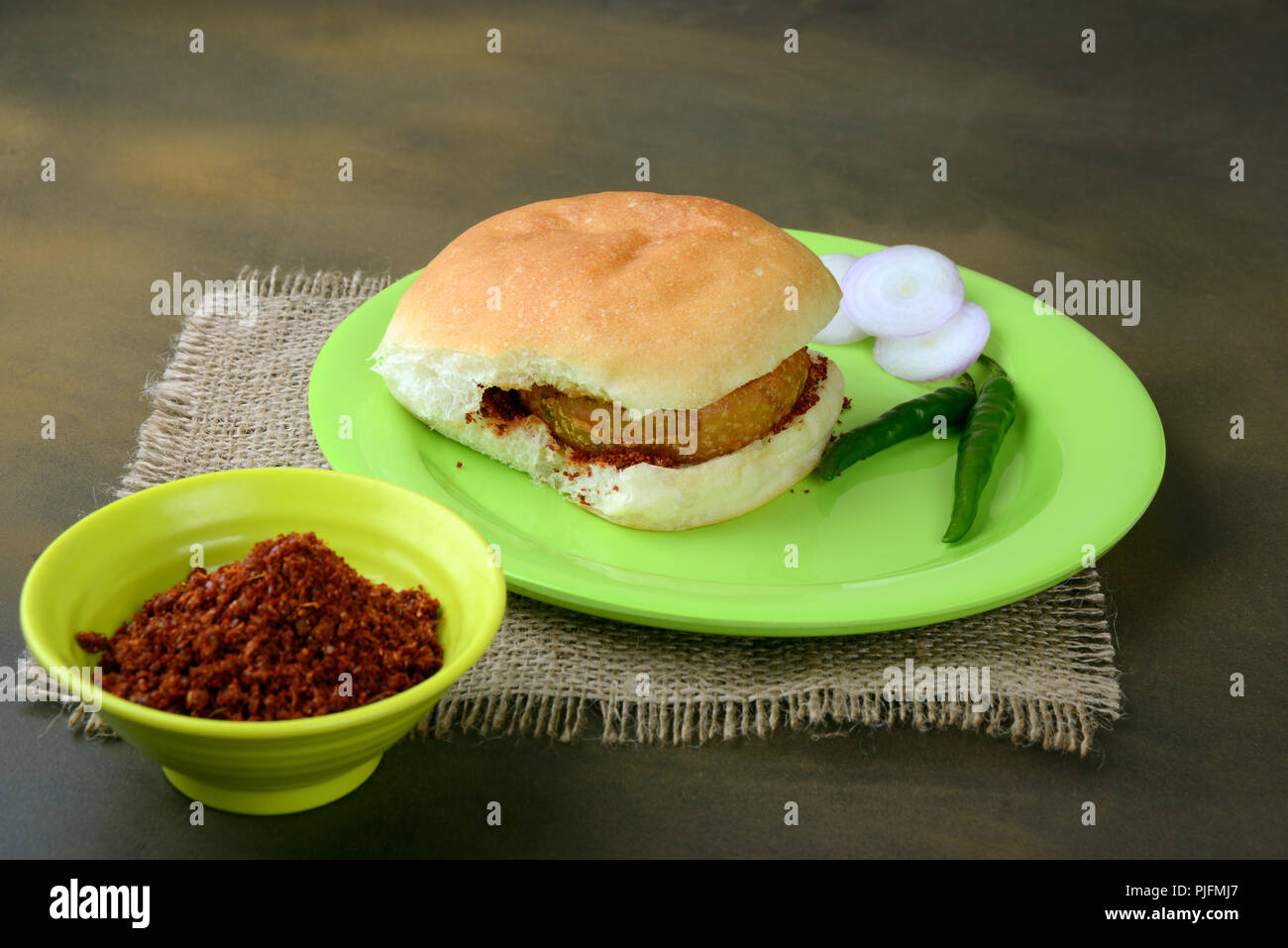 Vada Pav mit Zwiebel Green Chili und Knoblauch Chutney, einer beliebten Straße Nahrung in Indien Stockfoto