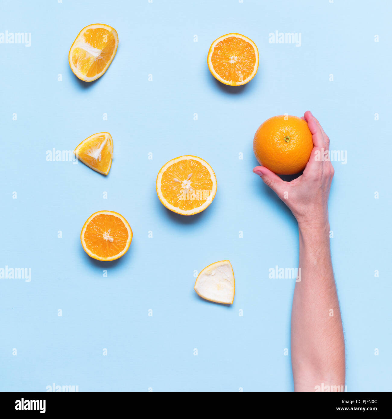 Weibliche Hand hält Ganzen Saft Orange Obst Schneiden Essen blauen Hintergrund der Ansicht von oben Flach Stockfoto