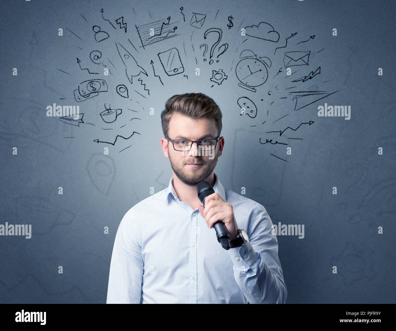 Geschäftsmann sprechen in das Mikrofon mit gemischten Doodles über seinem Kopf Stockfoto