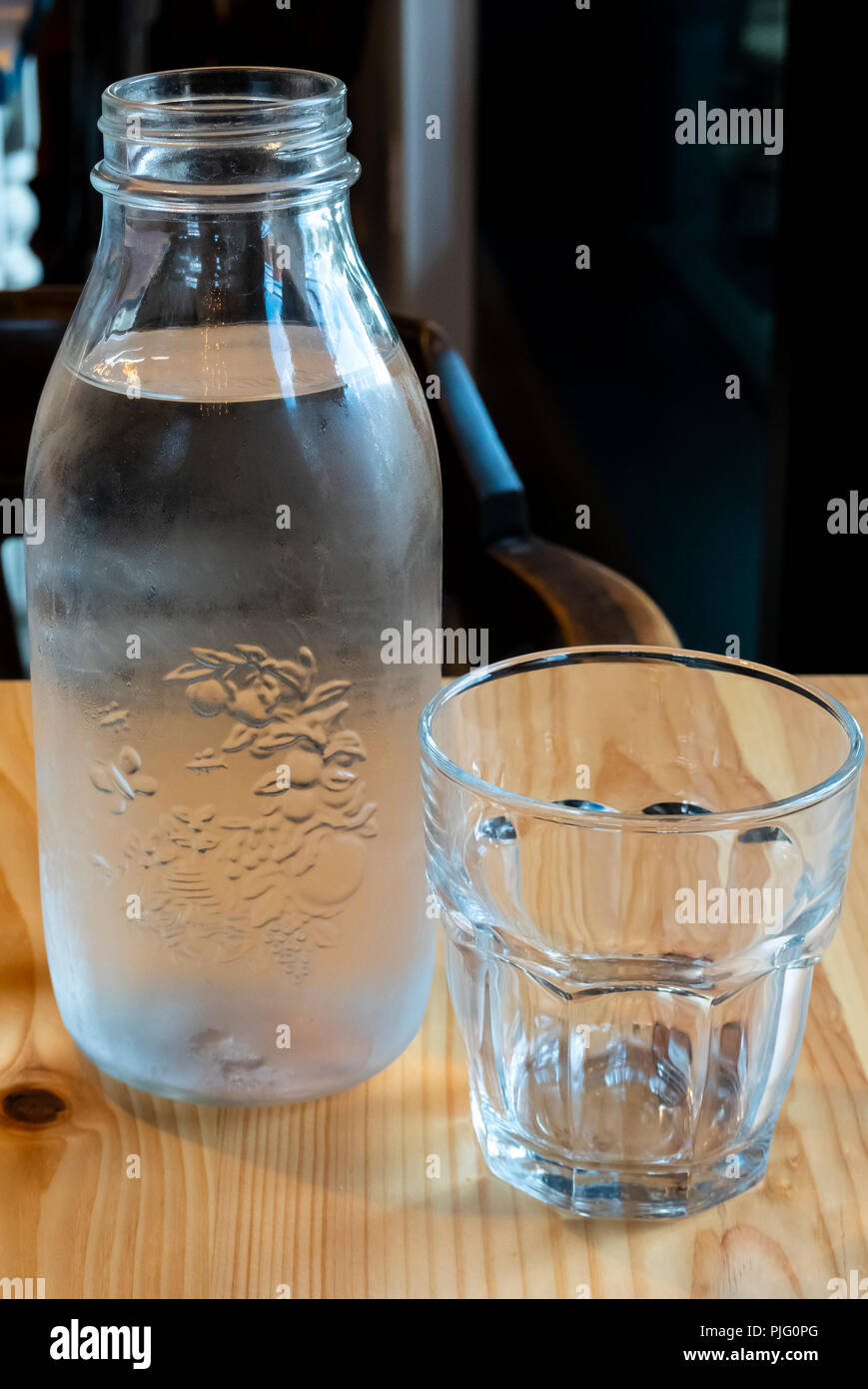 Fancy designer Flasche kaltes Wasser und Glas auf einem Tisch im Restaurant Stockfoto