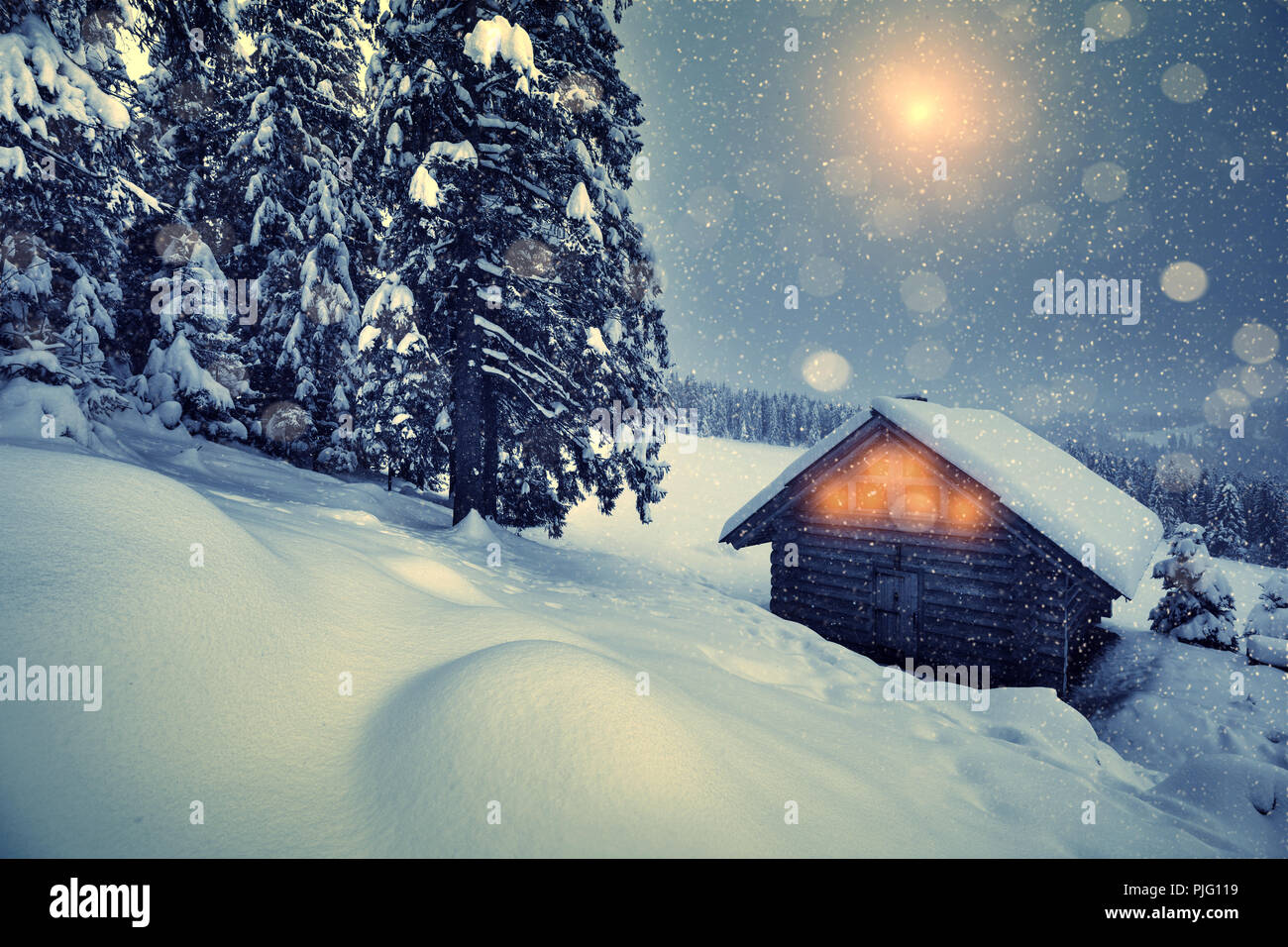 Weihnachten Schneefall in den Bergen. Schönen Winter Weihnachten Nacht auf Hügeln. Winterlandschaft mit Holzhaus und Weihnachten Wald. Weihnachten Hintergrund. Stockfoto
