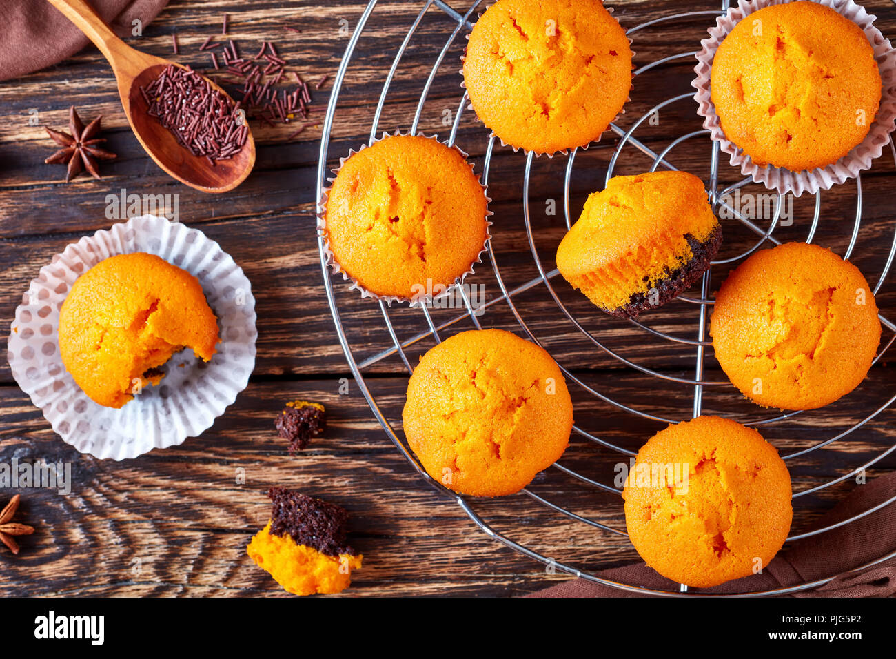 Frisch gebackene leckere Süße Kürbis Muffins auf einem rustikalen Holztisch, leckere Herbst Dessert für Halloween oder potluck Party, Nahaufnahme, flach Stockfoto