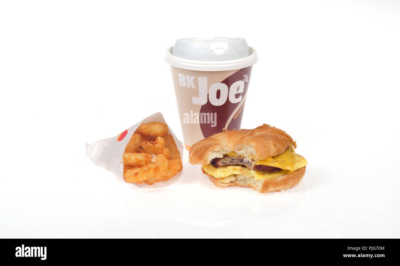 Burger King Frühstück mit Kaffee, Wurst, Ei und Käse croissan', oder Croissant Sandwich und Hash Brown Kartoffeln Stockfoto