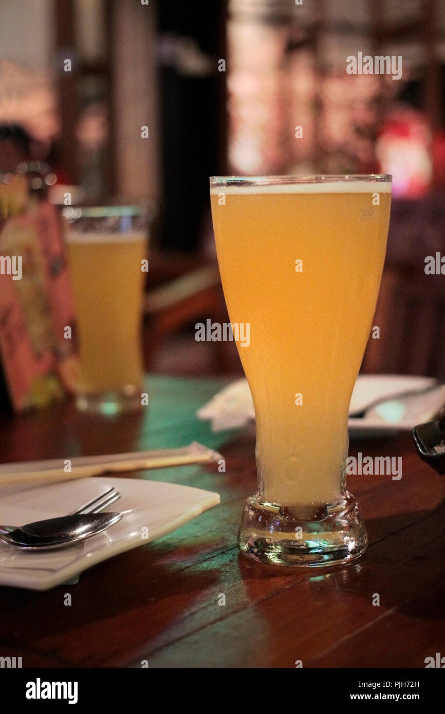 Zwei Gläser Bier auf dem Tisch liegen, bevor einige von Lebensmitteln in einem Restaurant serviert. Stockfoto