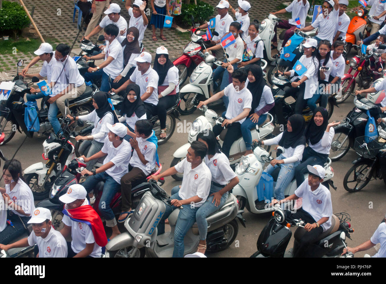 Eine Gruppe von jungen kambodschanischen Volkspartei Unterstützer der Menschen reiten Motorräder während einer Wahlkampfveranstaltung auf einer Straße der Stadt in Kampong Cham, Kambodscha. Stockfoto