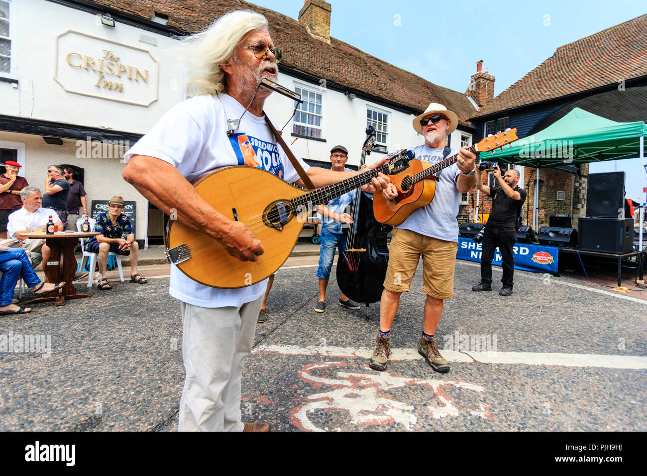 Steve Moreham mit seiner Band Krise in der mittelalterlichen Stadt Sandwich in England. Auf der Straße stand außerhalb des 14. Jahrhunderts Crispin Inn Stockfoto