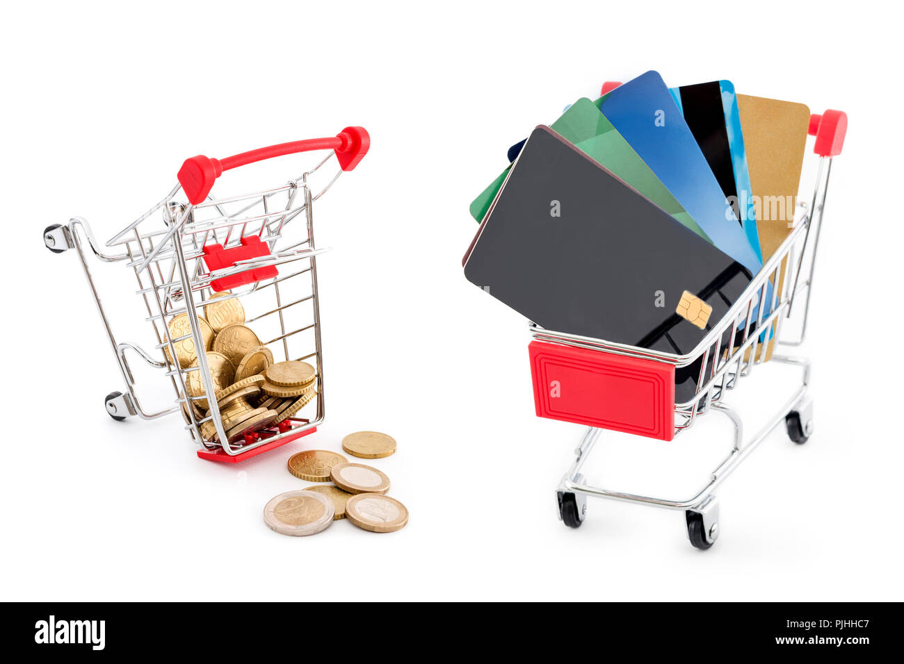 Shopping Cart mit Kreditkarten und anderen Warenkorb voller Euro-Münzen, die von fallen Sie auf weißem Hintergrund. Kreditkarten werden gewinnen und Cash ist besiegt Stockfoto