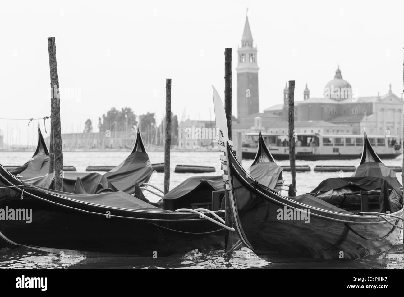 Gondeln günstig zu den Polen im Vordergrund und die Kirche San Giorgio Maggiore im Hintergrund, schwarz-weiß Fotografie mit einem Winter atm Stockfoto