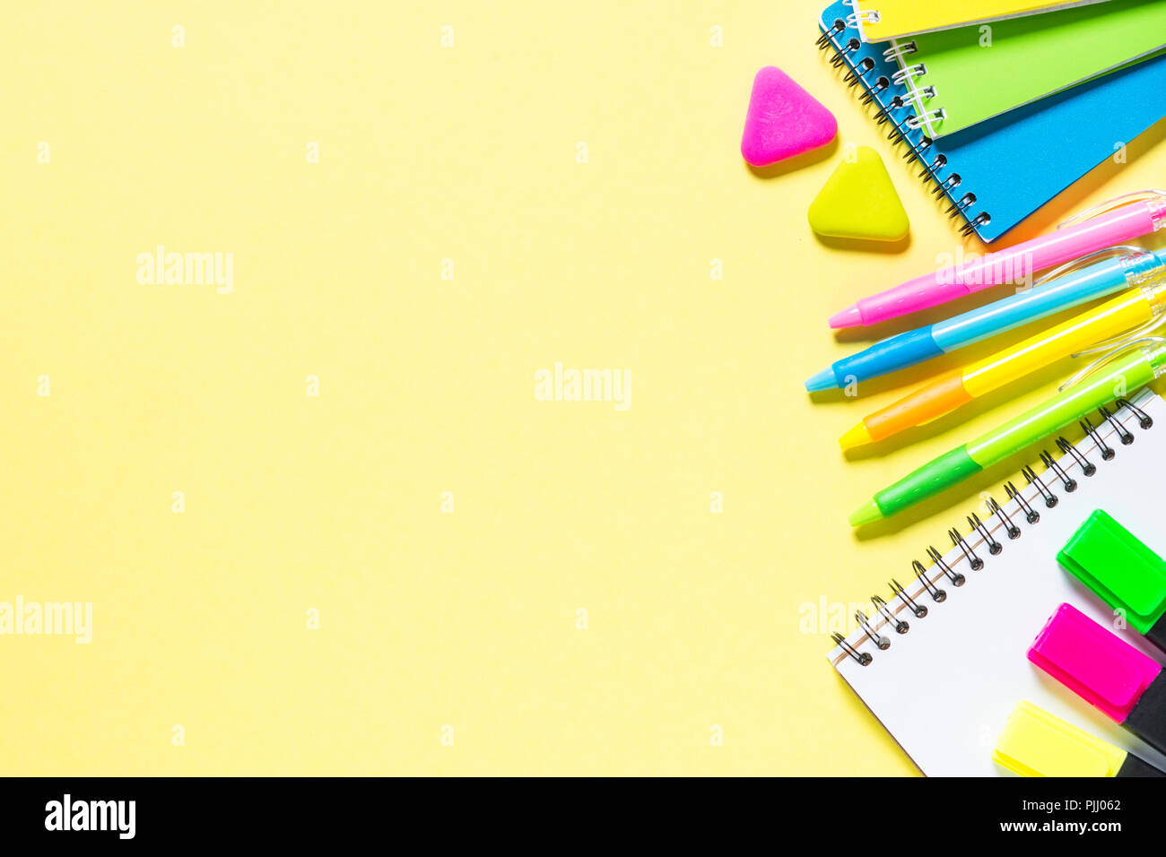 Schule und Büro sstationery auf gelben Hintergrund. Notebook, Notizblock, Kugelschreiber, Bleistifte, Marker und Material. Ansicht von oben mit der Kopie. Stockfoto