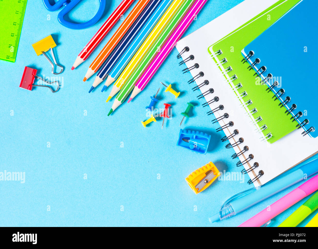 Zurück zum Konzept der Schule. Notebook, Notizblock, Kugelschreiber, Bleistifte, Büroklammern und Material. Ansicht von oben mit der Kopie. Stockfoto