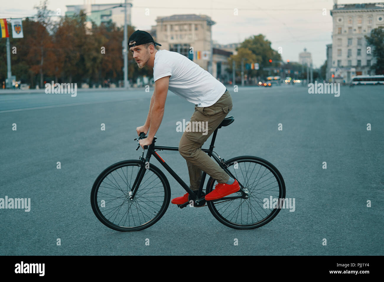 Seitenansicht junge moderne Mensch Radfahren auf einem klassischen Fahrrad auf die City Road. Kopieren Sie Platz. Aktive und ökologischen Lebensstil Konzept Stockfoto