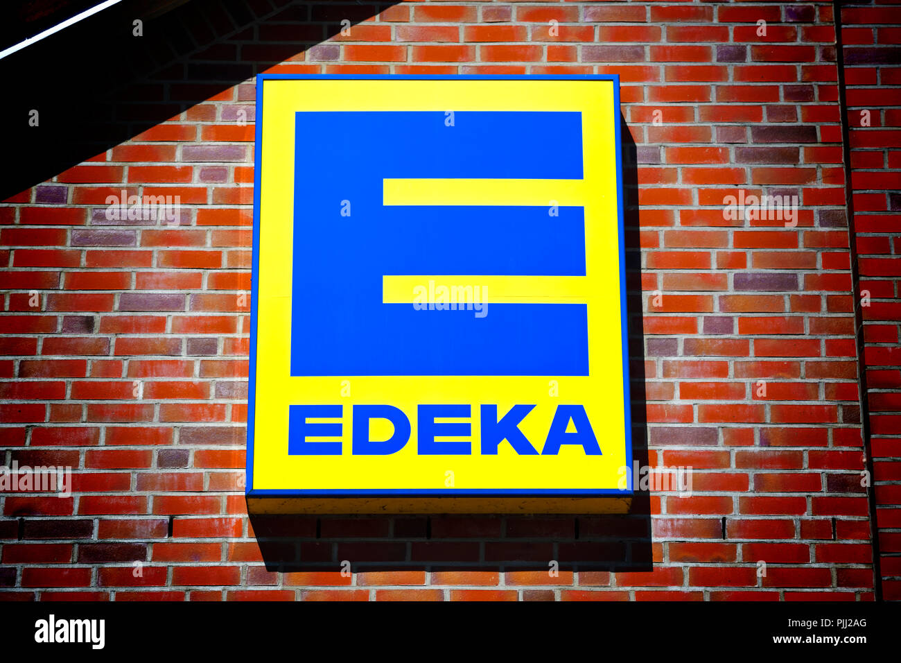 Zeichen für einen Lebensmittelmarkt EDEKA in Hamburg, Deutschland, Schild in Hamburg des EDEKA-Lebensmittelmarktes, Deutschland Stockfoto