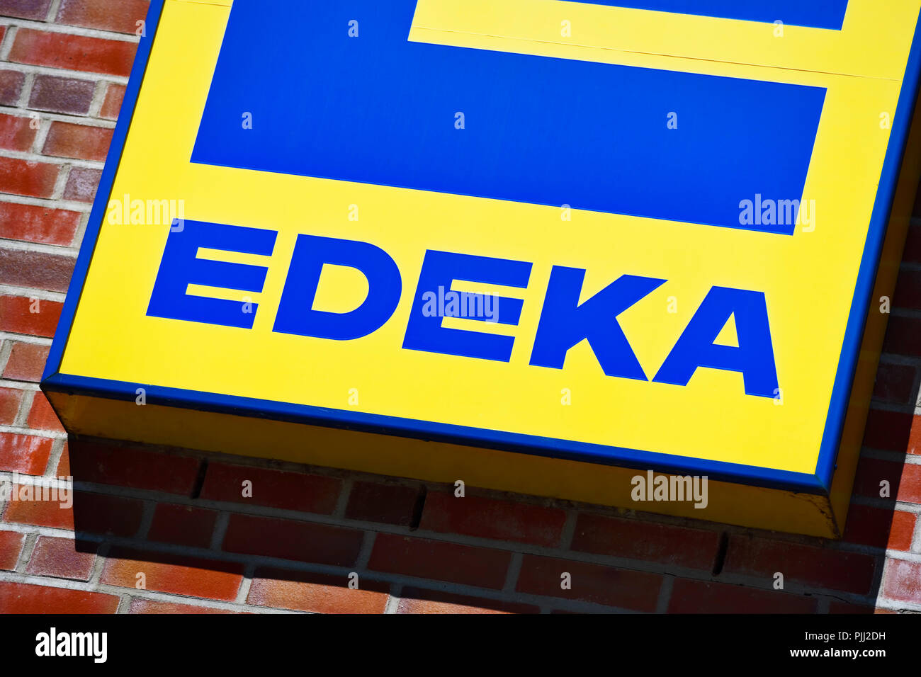 Zeichen für einen Lebensmittelmarkt EDEKA in Hamburg, Deutschland, Schild in Hamburg des EDEKA-Lebensmittelmarktes, Deutschland Stockfoto