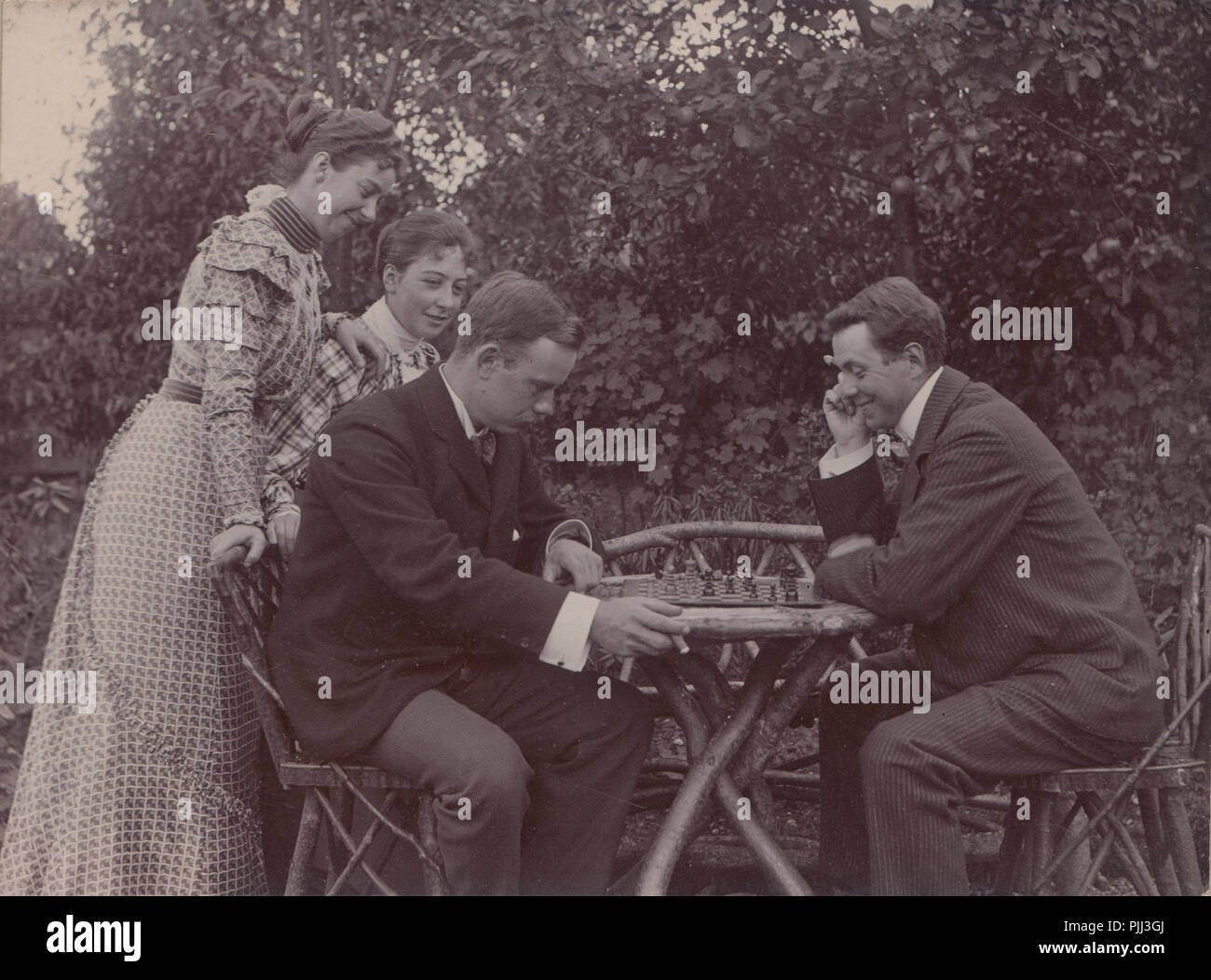 Viktorianische Kabinett Karte von Zwei Männer spielen Schach im Garten. Durch die zwei Damen aufgepaßt. Stockfoto