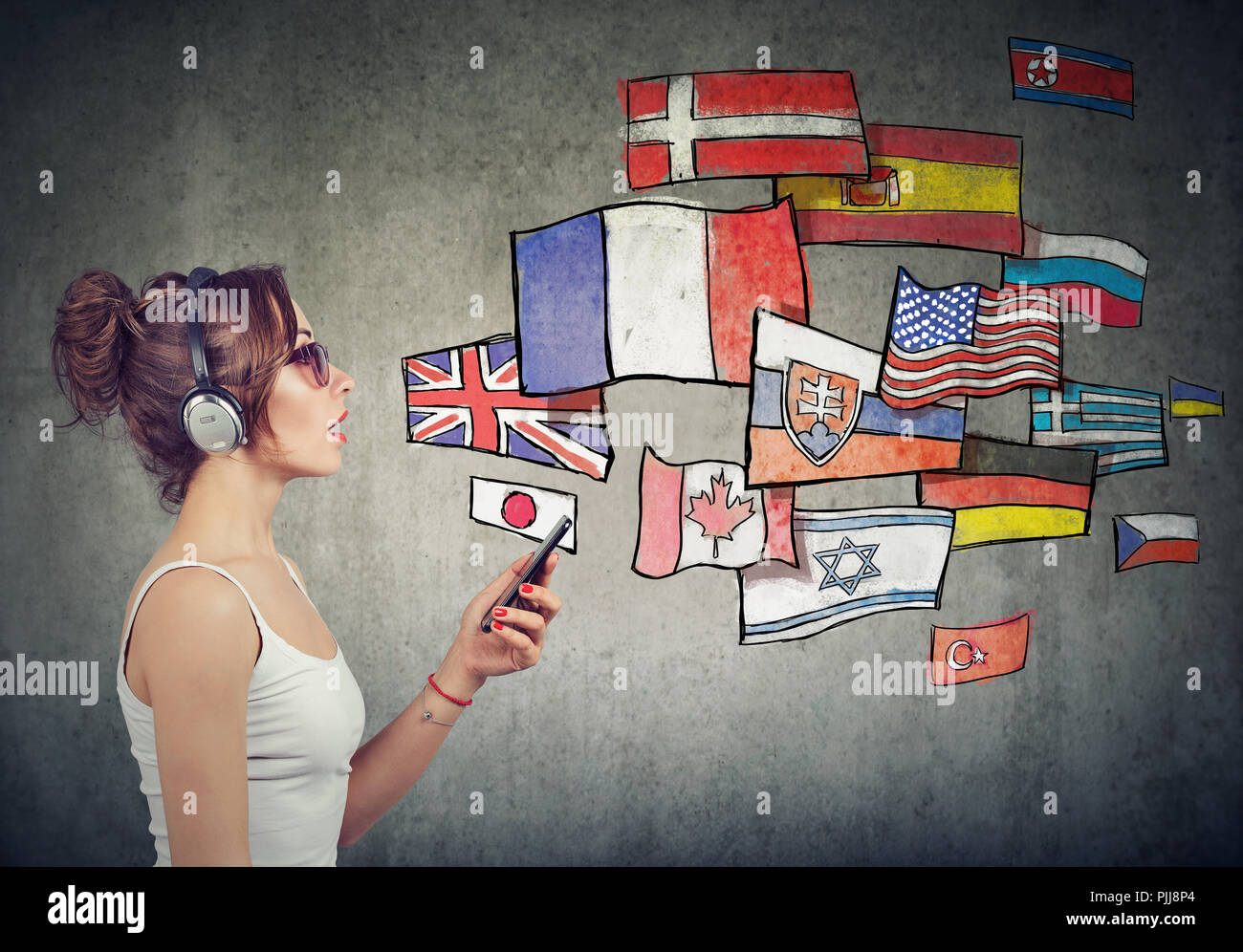Junge Frau in Kopfhörer mit Smartphone lernen verschiedene Sprachen Stockfoto