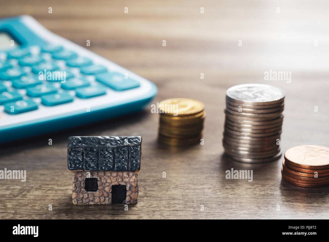 Haus Modell, Stapel von Münzen und Rechner. Konzept im Haus Verkauf, Kauf, Darlehen und Finance. Stockfoto