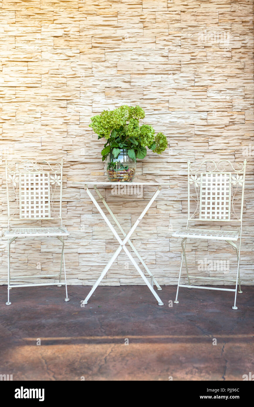 Ein Garten Tisch in der Nähe des Hauses. Mit einem großen, grünen, Blumenstrauß. Stockfoto