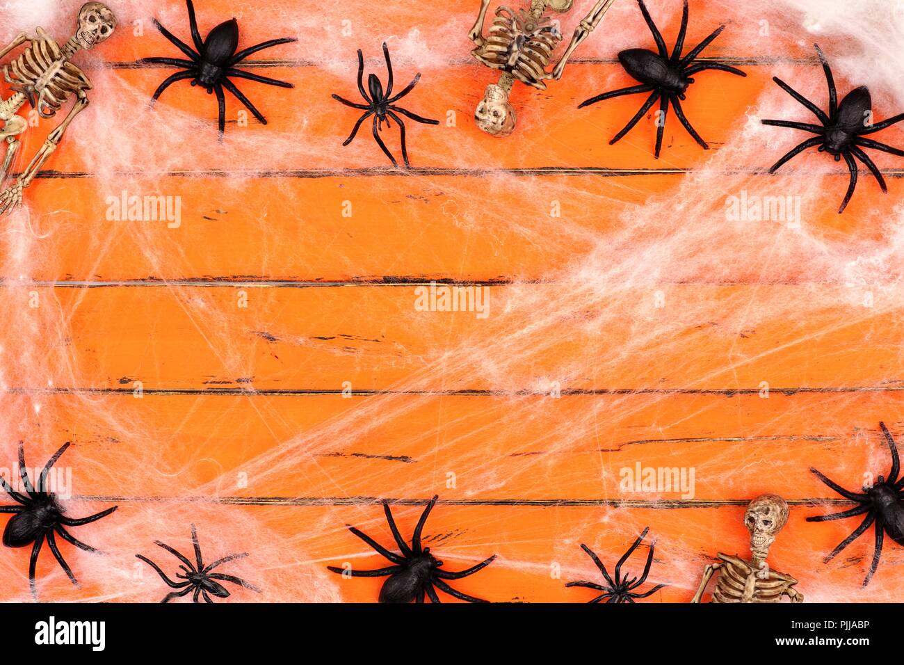 Halloween double Grenze mit Skeletten und Spinnweben auf einem alten orange Holz Hintergrund Stockfoto