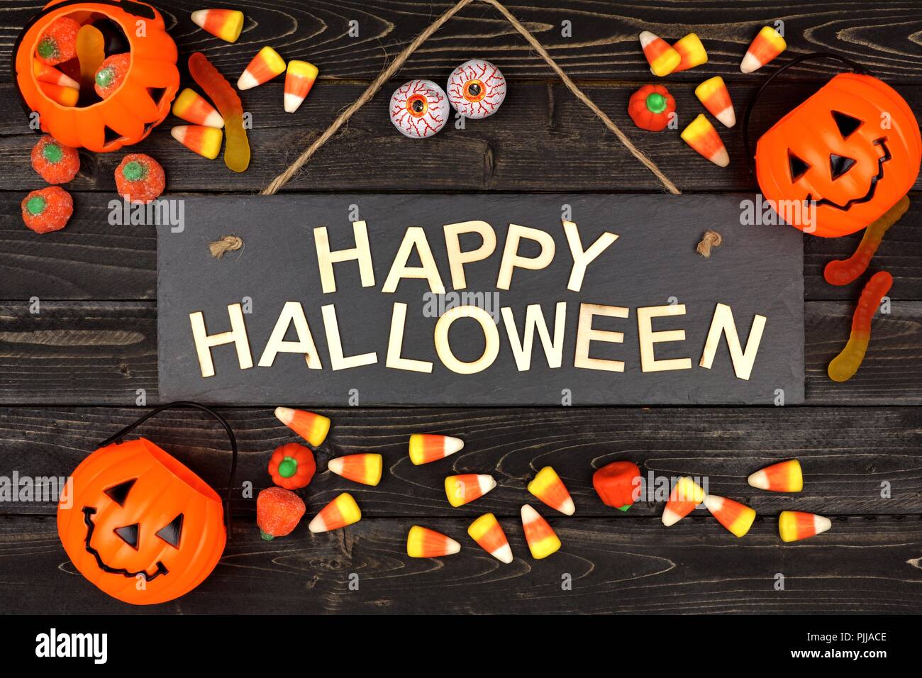 Happy Halloween schwarz mit Holz Buchstaben und Rahmen der Süßigkeit auf schwarzem Holz Hintergrund Stockfoto