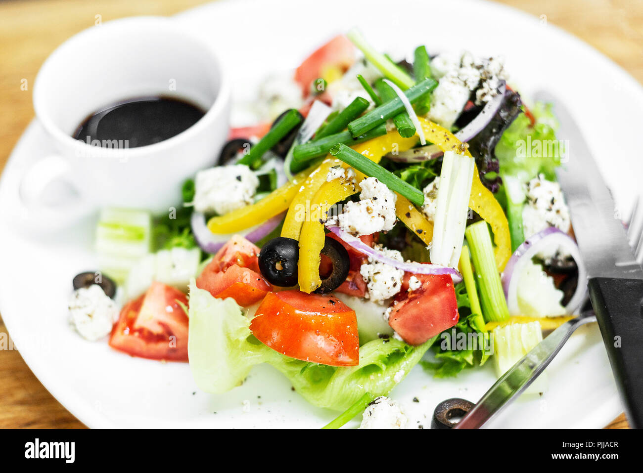 Traditioneller Griechischer Salat mit Feta und gemischte Bio Gemüse auf hölzernen Tisch Stockfoto