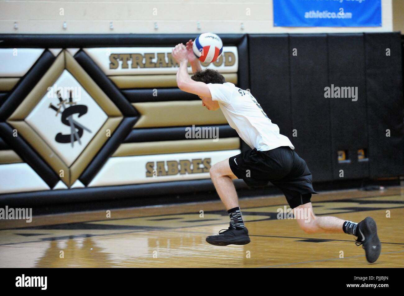 Spieler, die die Service Line beim Schlagen einer blinden Schuss über seinem Kopf in einer Bemühung, einen Volley lebendig zu halten. USA. Stockfoto