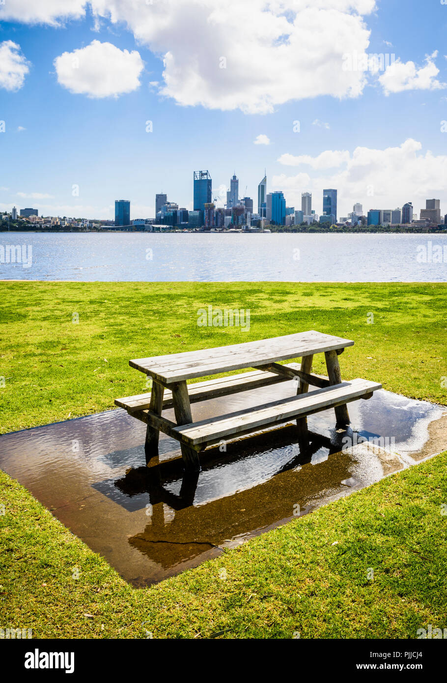 Holz- Picknick Tisch in einer großen Pfütze von Wasser durch den Swan River in Sir James Mitchell Park, South Perth, Western Australia Stockfoto