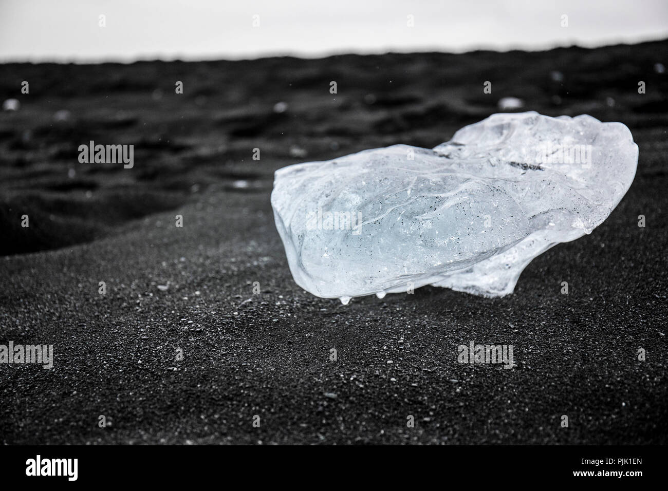 Ice Block vom Gletscher auf tiefen schwarzen Sand in Jökulsárlón, Island Stockfoto